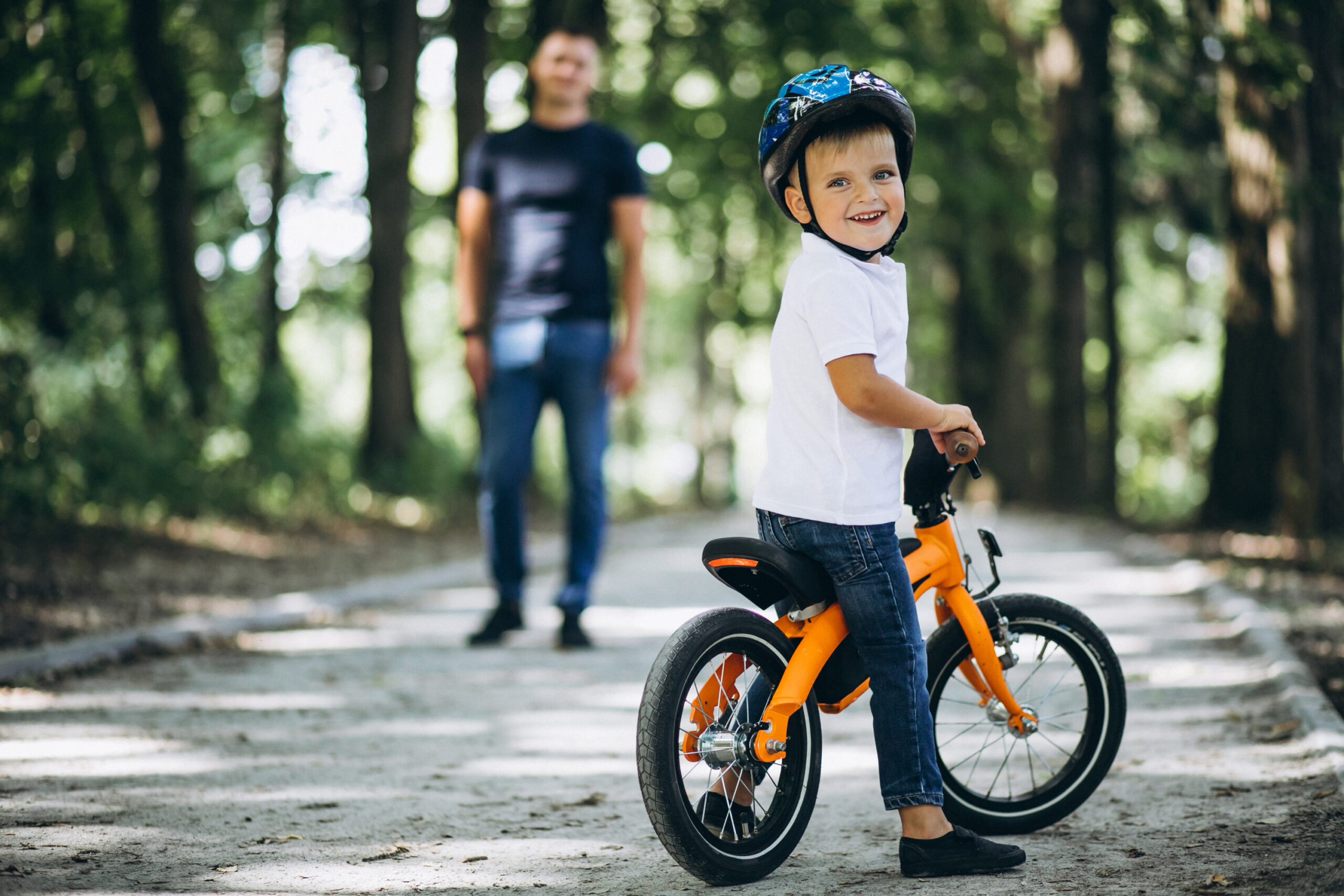 father teaching his little son ride bicycle scaled